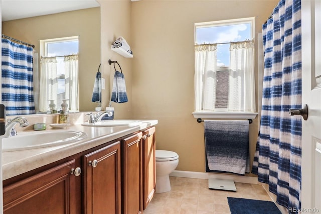 full bath featuring double vanity, toilet, a sink, and tile patterned floors