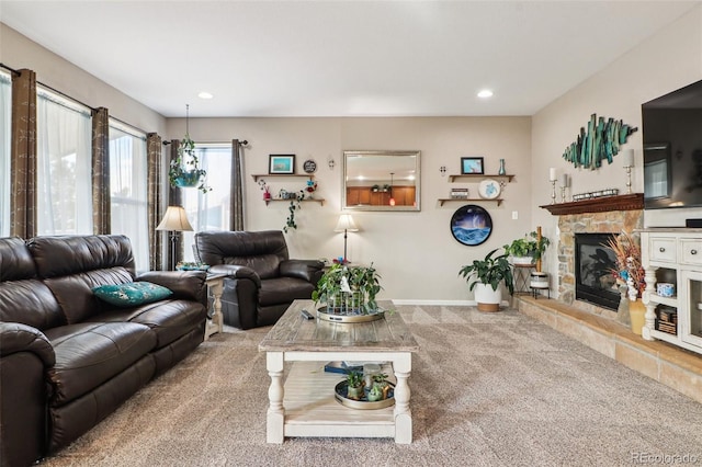 carpeted living area featuring a fireplace, baseboards, and recessed lighting