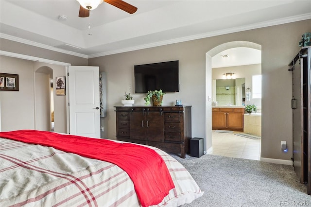 bedroom with baseboards, ensuite bathroom, ornamental molding, arched walkways, and light colored carpet
