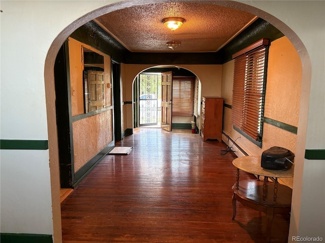 1337 Valentia St, Denver, CO 80220 - corridor featuring baseboard heating, wood finished floors, a textured ceiling, arched walkways, and a textured wall
