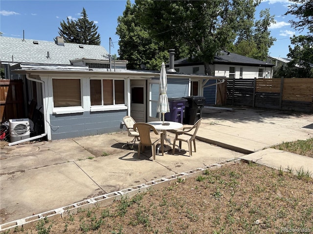1337 Valentia St, Denver, CO 80220 - rear view of property featuring a patio, roof with shingles, concrete block siding, and outdoor dining area