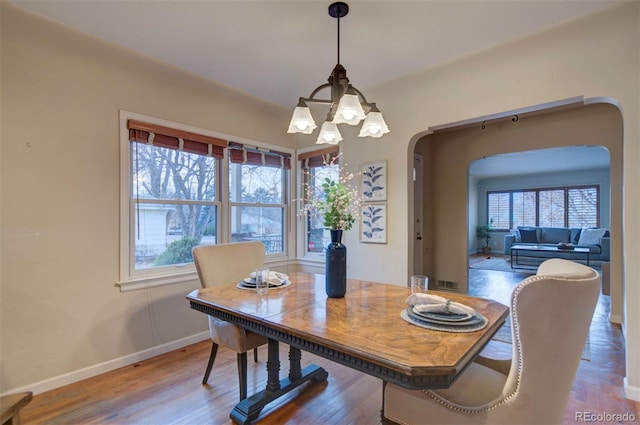 dining room with hardwood / wood-style flooring and a chandelier