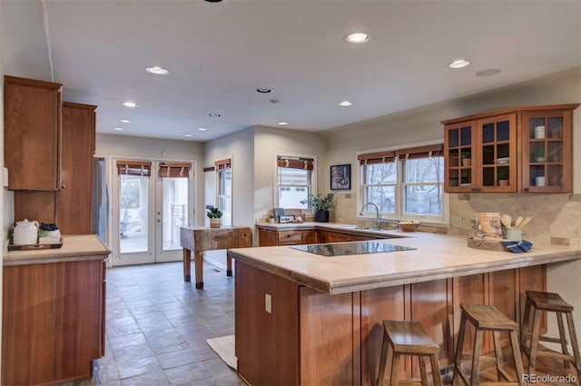 kitchen featuring sink, a breakfast bar area, black electric stovetop, and kitchen peninsula