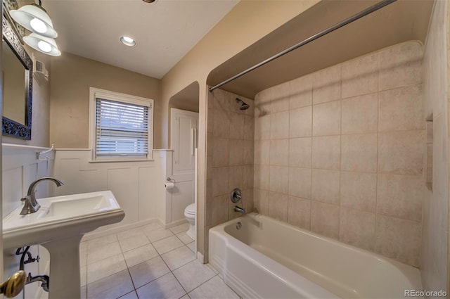 bathroom featuring tiled shower / bath combo, tile patterned floors, and toilet