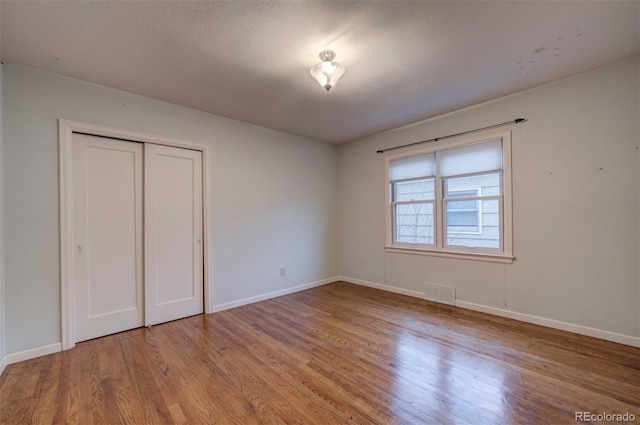 unfurnished bedroom featuring light wood-type flooring and a closet