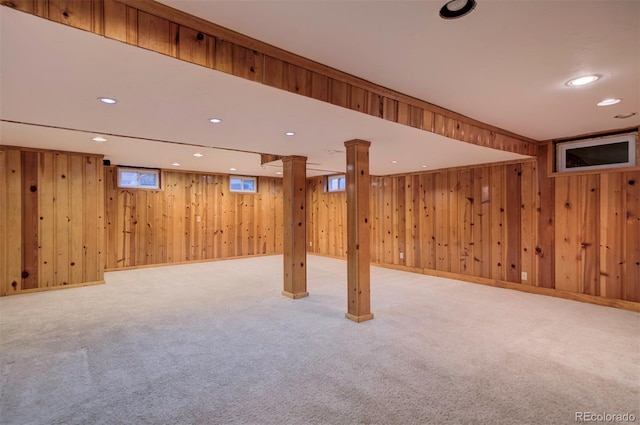 basement featuring wooden walls and carpet flooring