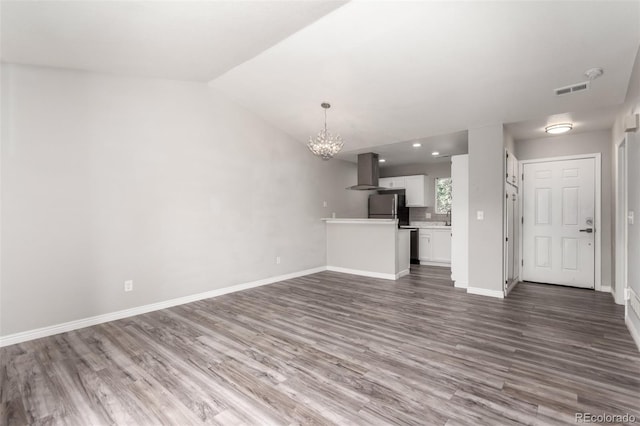 2267 S Buckley Rd Unit 202, Aurora, CO 80013 - unfurnished living room with wood finished floors, a chandelier, and vaulted ceiling