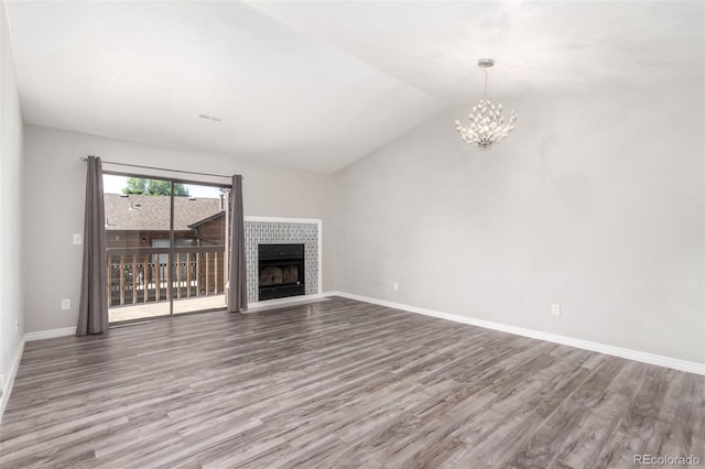 2267 S Buckley Rd Unit 202, Aurora, CO 80013 - unfurnished living room featuring wood finished floors, a chandelier, vaulted ceiling, and a tile fireplace