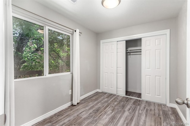 2267 S Buckley Rd Unit 202, Aurora, CO 80013 - unfurnished bedroom featuring wood finished floors and a closet