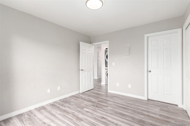 2267 S Buckley Rd Unit 202, Aurora, CO 80013 - unfurnished bedroom with stacked washing machine and dryer and light wood-type flooring