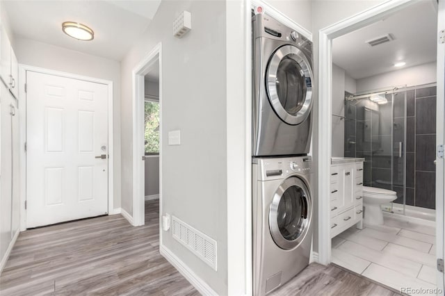 2267 S Buckley Rd Unit 202, Aurora, CO 80013 - laundry room featuring stacked washer / drying machine and light wood-style flooring
