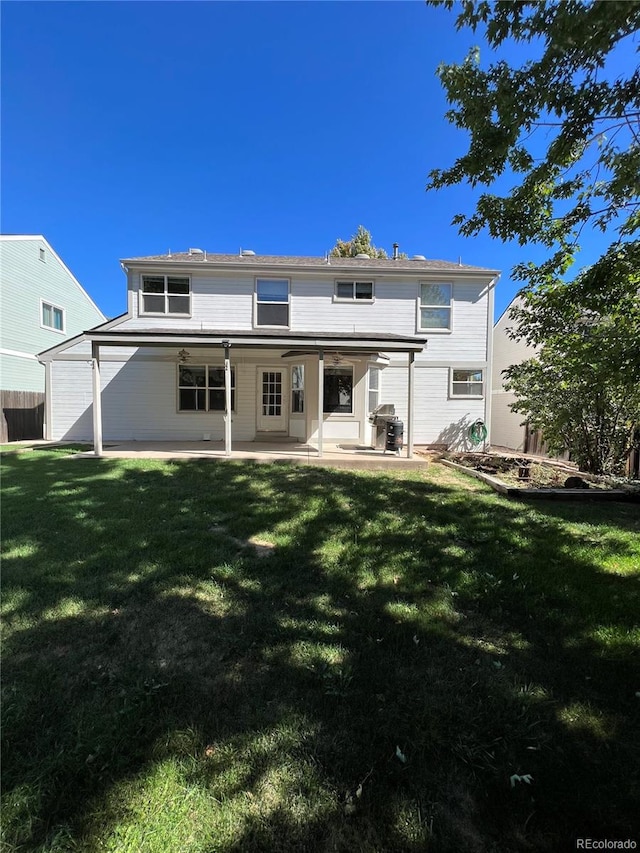 rear view of property featuring a lawn and a patio