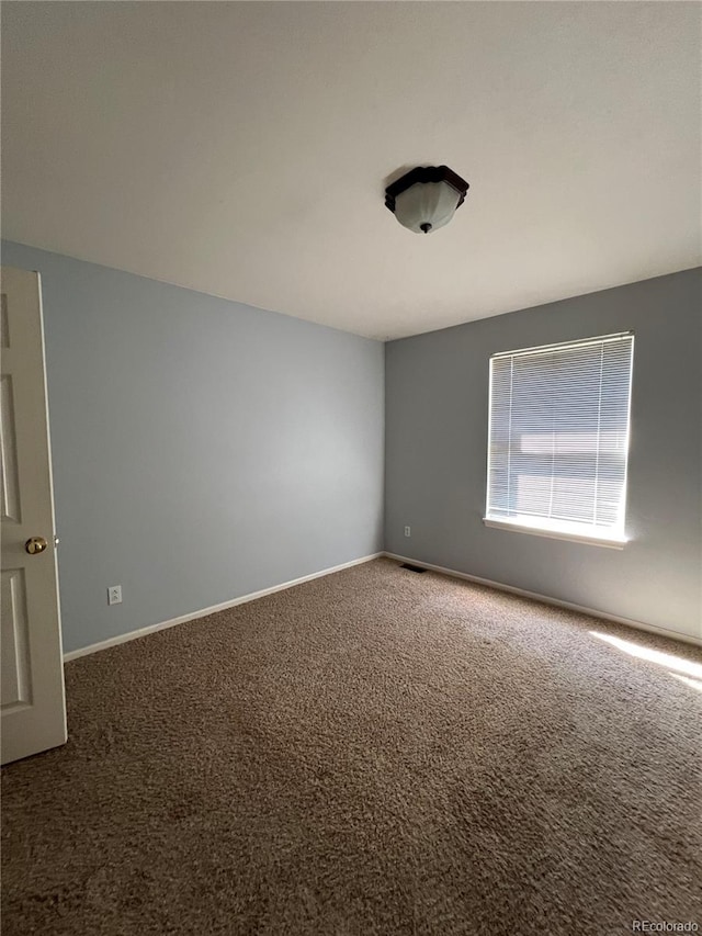 carpeted spare room with baseboards