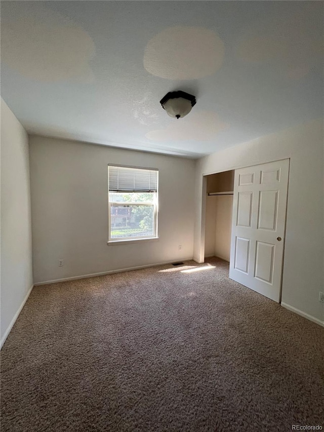 unfurnished bedroom with a closet and carpet flooring