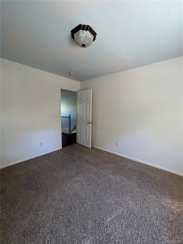 carpeted empty room with baseboards