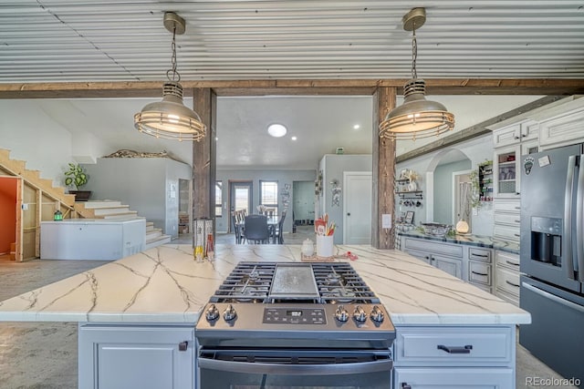 kitchen with pendant lighting, light stone countertops, a center island, stainless steel appliances, and white cabinets