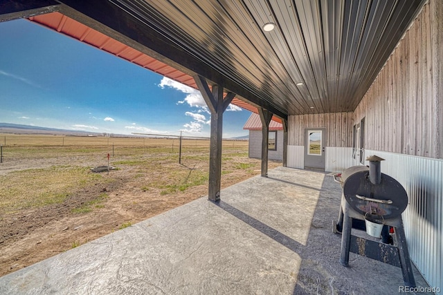 view of patio / terrace with fence and a rural view
