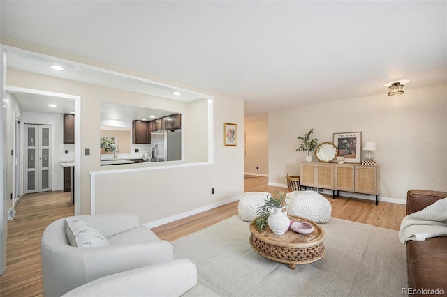 living area with recessed lighting, baseboards, and light wood finished floors