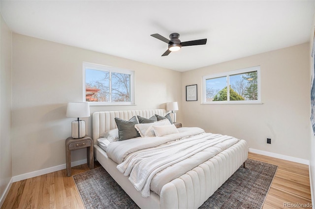 bedroom featuring baseboards, a ceiling fan, and light wood finished floors