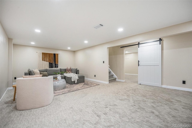 living area featuring a barn door, recessed lighting, visible vents, and baseboards