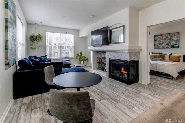 living room with light hardwood / wood-style floors and a multi sided fireplace