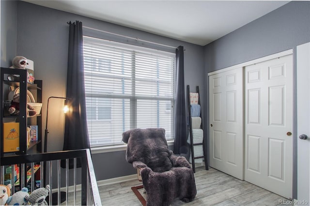 bedroom featuring multiple windows, a closet, and light wood-type flooring