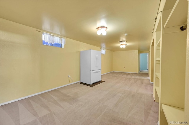 basement featuring light colored carpet and white fridge