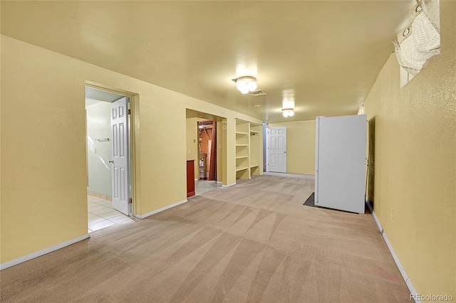 interior space featuring built in shelves and light carpet