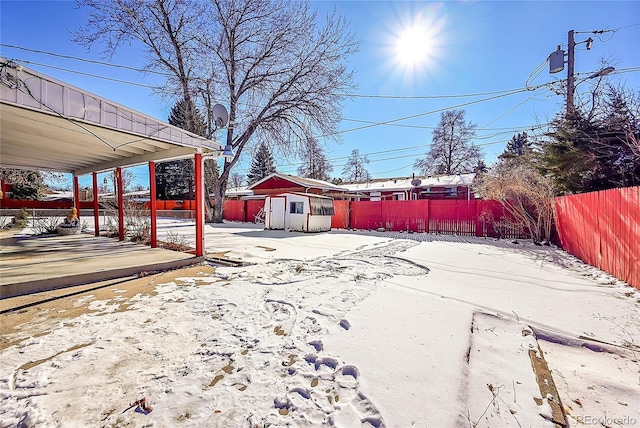 yard layered in snow with an outbuilding