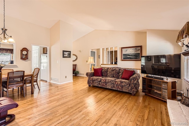 9925 W Progress Pl, Littleton, CO 80123 - living area with light wood-type flooring, vaulted ceiling, and a chandelier