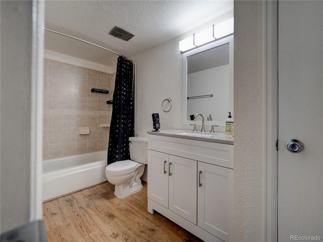 14590 E 2nd Ave Unit 105B, Aurora, CO 80011 - full bath with wood finished floors, vanity, shower / bath combo, a textured ceiling, and a textured wall
