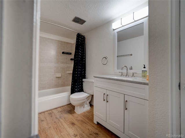 14590 E 2nd Ave Unit 105B, Aurora, CO 80011 - full bathroom with wood finished floors, a textured wall, vanity, a textured ceiling, and shower / tub combo