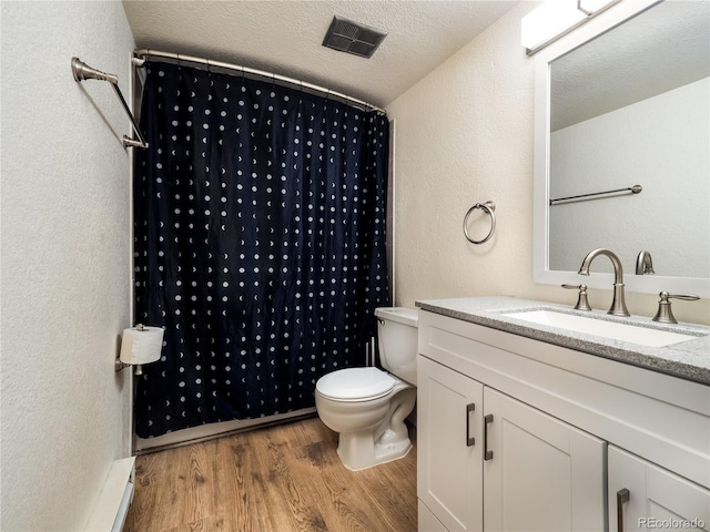14590 E 2nd Ave Unit 105B, Aurora, CO 80011 - full bathroom with wood finished floors, vanity, a textured wall, a shower with curtain, and baseboard heating