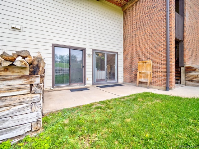 14590 E 2nd Ave Unit 105B, Aurora, CO 80011 - view of exterior entry featuring a patio area, a yard, and brick siding