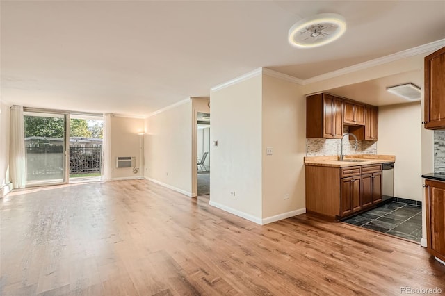 unfurnished living room with crown molding, a wall mounted air conditioner, sink, and dark hardwood / wood-style flooring