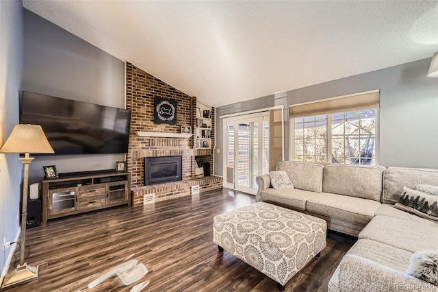 living room with dark hardwood / wood-style flooring, vaulted ceiling, and a brick fireplace