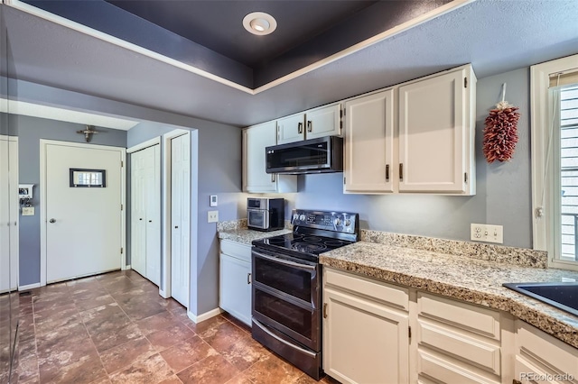 kitchen featuring stainless steel appliances, a healthy amount of sunlight, white cabinets, and light stone counters