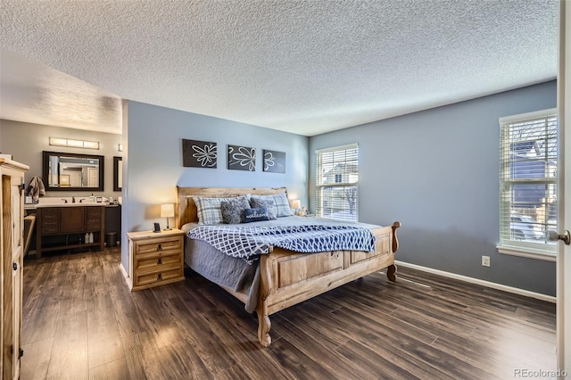 bedroom featuring multiple windows, connected bathroom, dark hardwood / wood-style flooring, and a textured ceiling