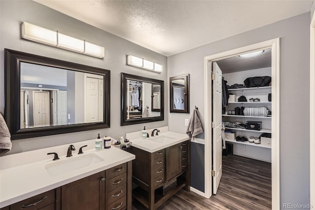 bathroom featuring vanity, hardwood / wood-style flooring, and a textured ceiling