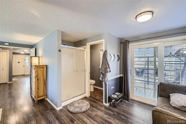 interior space featuring a barn door, dark wood-type flooring, and a textured ceiling