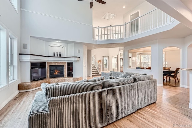 living room featuring a healthy amount of sunlight, a premium fireplace, and light wood-type flooring