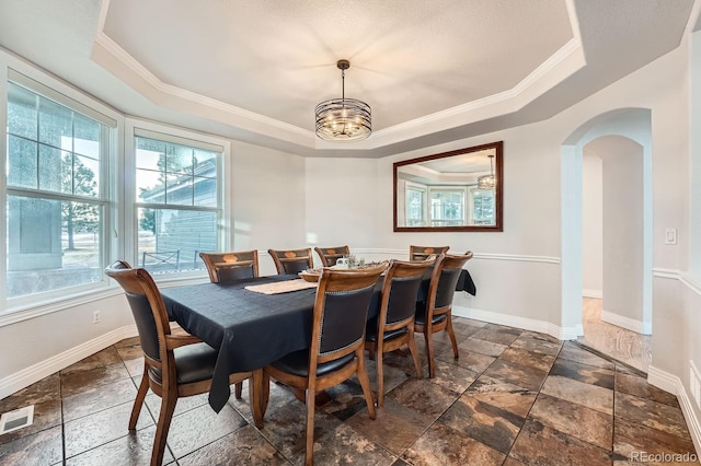 dining space featuring crown molding, a chandelier, and a tray ceiling