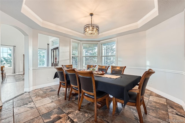 dining room featuring ornamental molding, a tray ceiling, and a notable chandelier