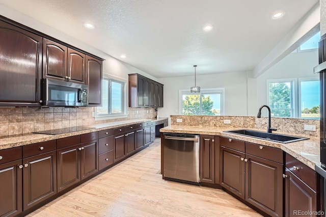 kitchen with pendant lighting, dark brown cabinetry, stainless steel appliances, and sink