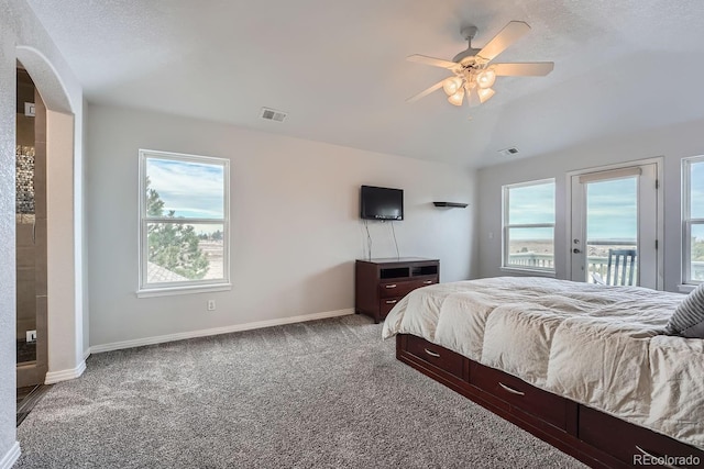 carpeted bedroom with multiple windows, vaulted ceiling, access to outside, and ceiling fan