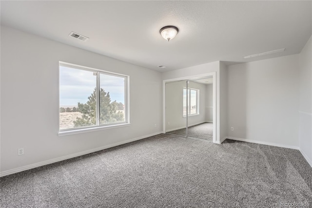 unfurnished bedroom featuring carpet floors and a closet