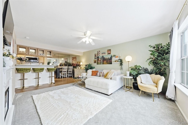 living area featuring light wood-style flooring and a ceiling fan