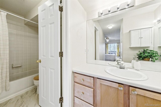 bathroom with toilet, vanity, a ceiling fan, marble finish floor, and shower / bath combo