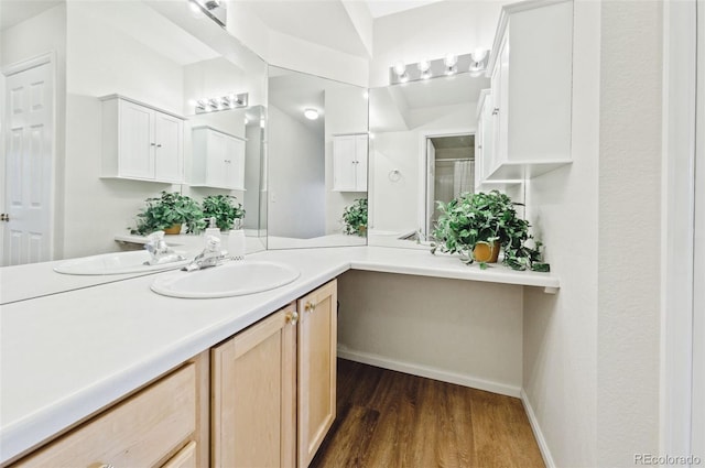 bathroom featuring baseboards, wood finished floors, and vanity