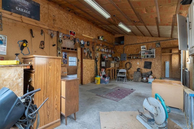 garage with a workshop area and electric panel